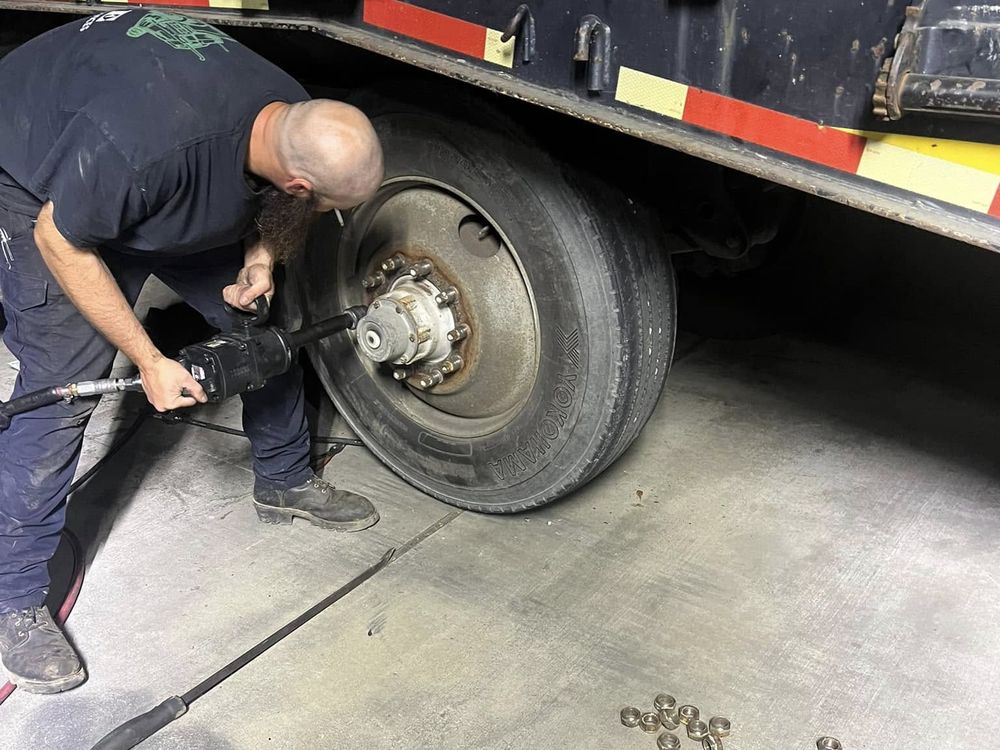Technician removing a trailer wheel for brake and hub service