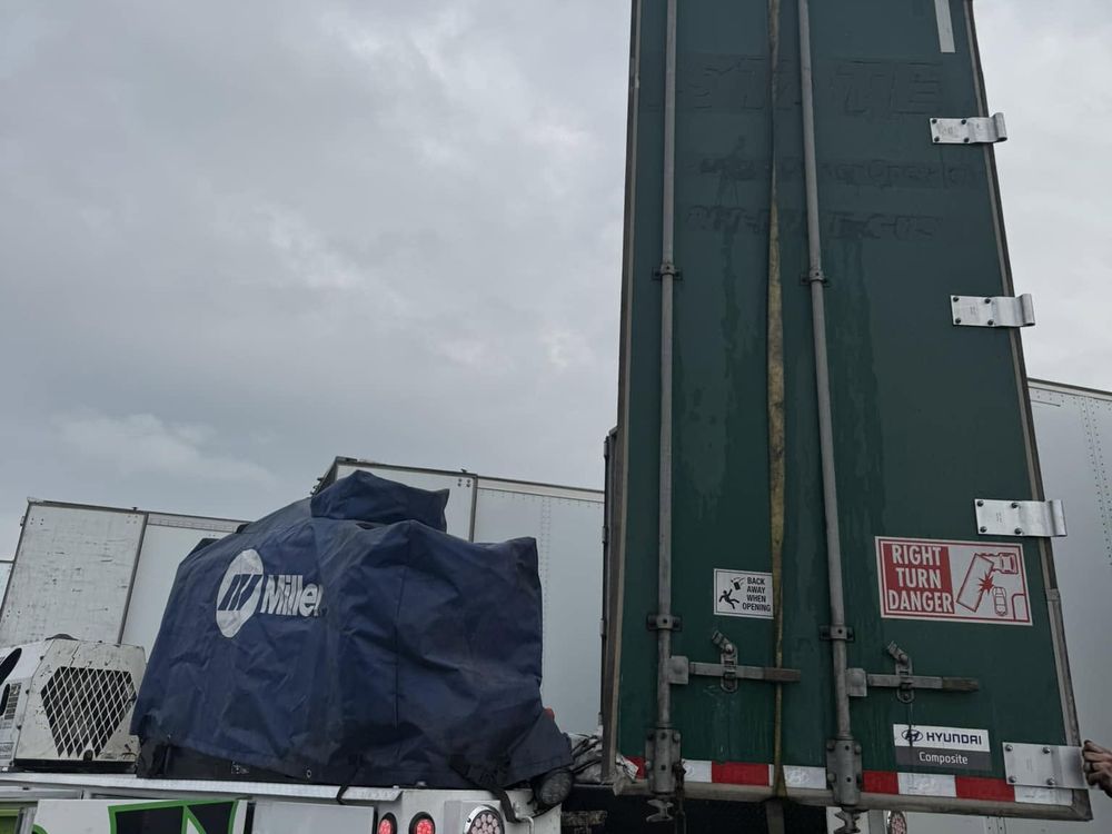 Welding equipment set up beside a semi trailer for repair